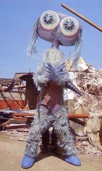 巨大な二つの眼 ・水色と紫のポップな体色 ・左右の肘に装備する刀